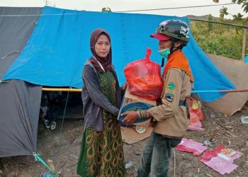 Andi Achmar Fadli M ketika membagikan bantuan di posko pengungsian