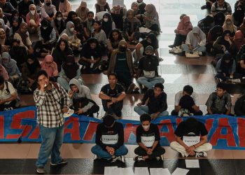 Kerumunan massa demonstrasi duduk menanti pertemuan dengan Rektor Unhas di Depan Rektorat, Senin (03/04). Sumber: IDENTITAS/Agif