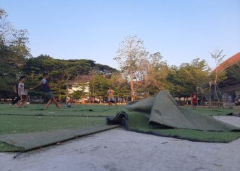 Anak-anak tetap bermain bola meskipun rumput sintetis lapangan memburuk, bahkan terangkat, Rabu (20/09).  Sumber: IDENTITAS/MYB