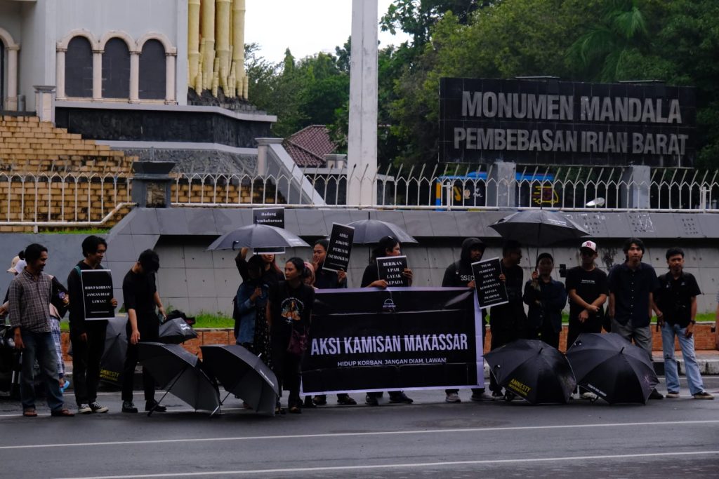 Sekumpulan relawan yang menggelar Aksi Kamisan lengkap dengan ciri khas baju dam payung hitamnya.