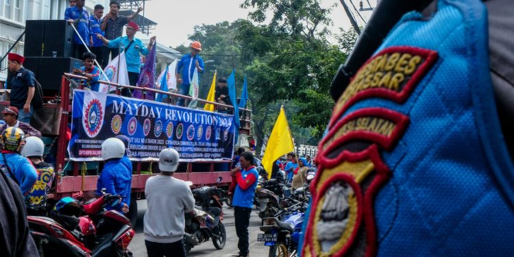 Buruh yang menyampaikan tuntutan dan keresahan mereka dari atas mobil, Rabu (01/05).