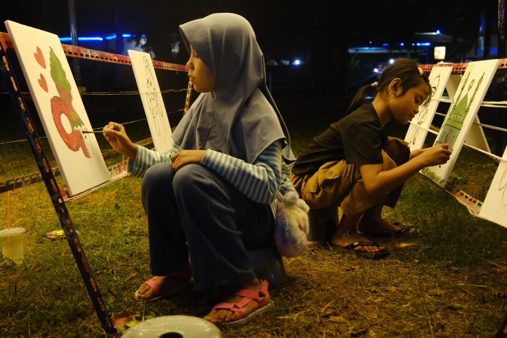 Pengunjung anak-anak mewarnai di penyedia alat lukis.