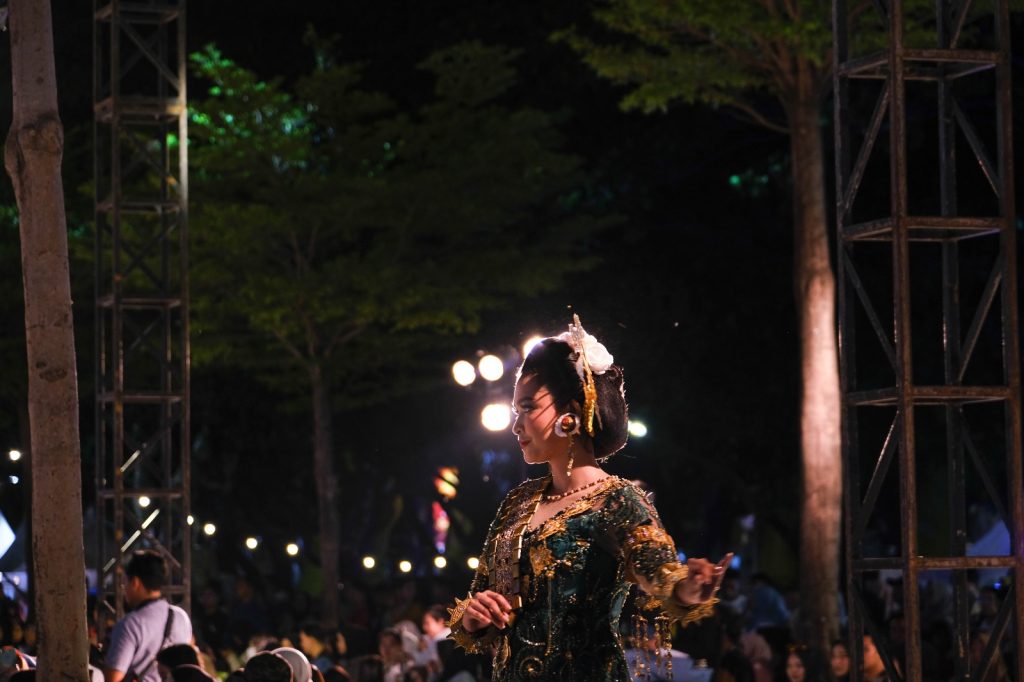 Peraga wanita mengikuti fashion show menggunakan salah satu baju adat.