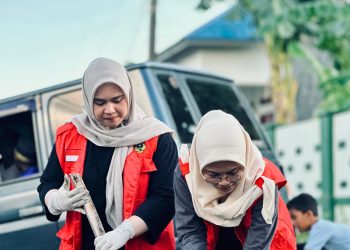 Tampak dua mahasiswa KKN saat melakukan pembersihan drainase. Foto: Dokumentasi Pribadi.