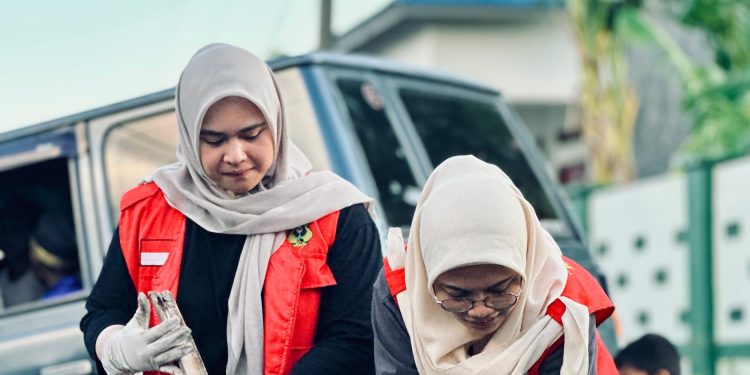 Tampak dua mahasiswa KKN saat melakukan pembersihan drainase. Foto: Dokumentasi Pribadi.