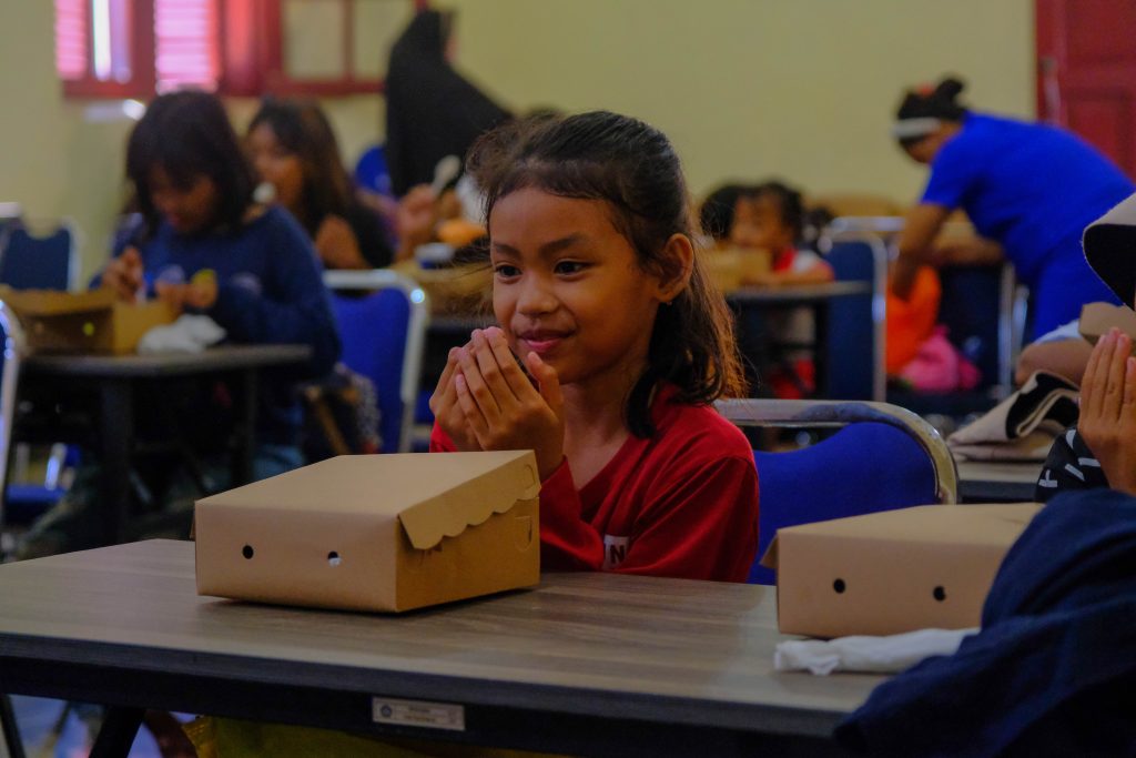 Seorang anak yang membaca doa sebelum bersantap siang