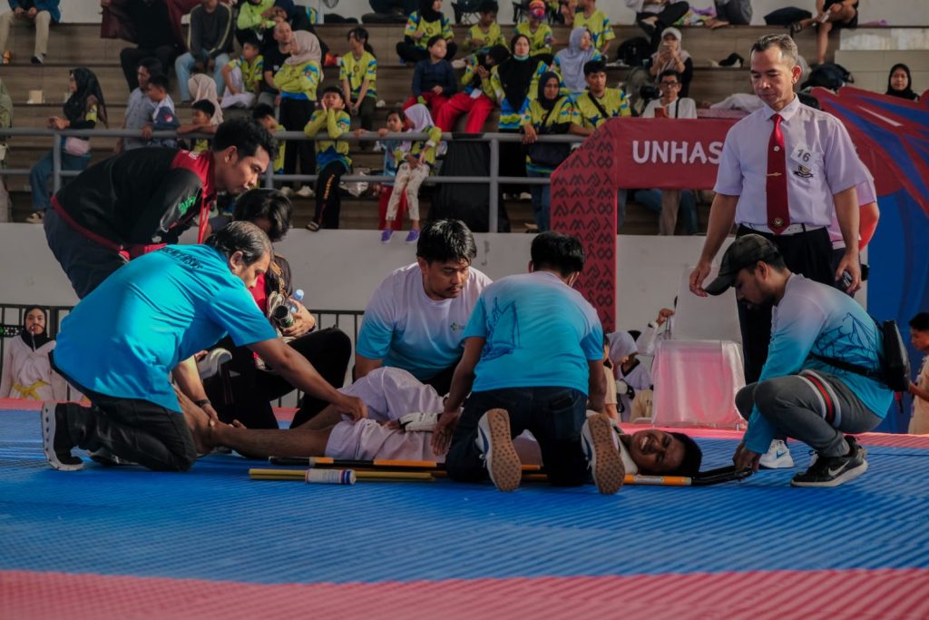 Pertolongan tim medis kepada seorang atlet yang terkapar kesakitan