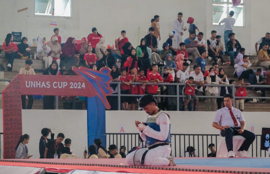 Atlet taekwondo berlutut dan berdoa sebelum pertandingannya