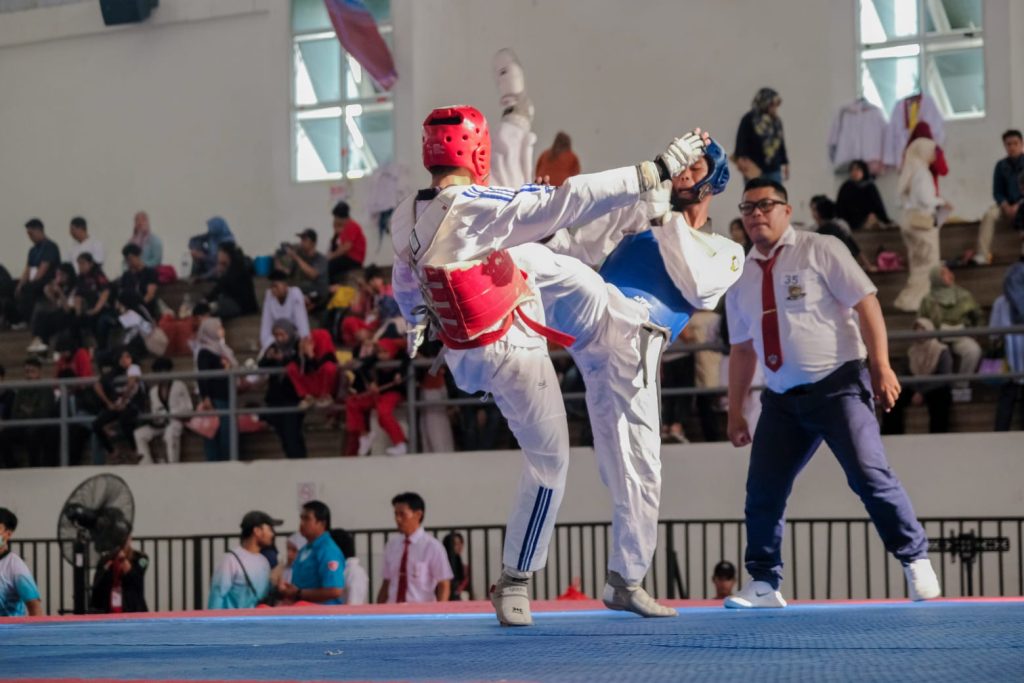 Dua atlet taekwondo yang saling melayangkan tendangan