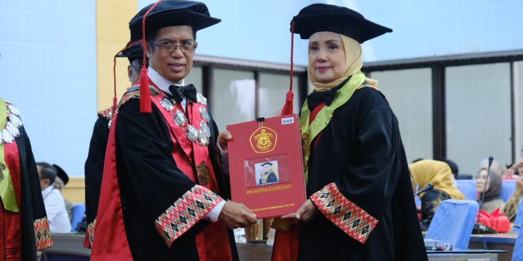 Prof Dr dr Andi Kurnia Bintang SpS(K) MKes (kanan) menerima kode etik anggota Dewan Profesor setelah dikukuhkan sebagai Guru Besar FK Unhas di Ruang Senat Lantai 2 Gedung Rektorat Unhas, Rabu (22/01). Foto: IDENTITAS/Ismail Basri.