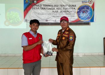 Tampak Briket dari Limbah Jagung yang berbentuk tabung itu diserahkan Hisyam (kiri) kepada Kepala Desa Tanjonga, Rajamuda Sewang (kanan), Senin (03/02). Foto: Dokumentasi Pribadi