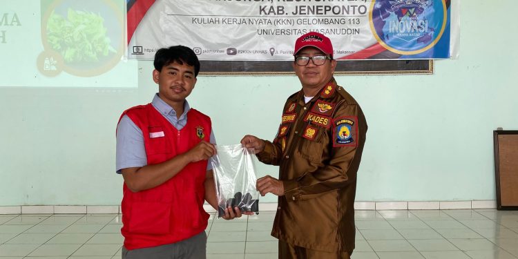 Tampak Briket dari Limbah Jagung yang berbentuk tabung itu diserahkan Hisyam (kiri) kepada Kepala Desa Tanjonga, Rajamuda Sewang (kanan), Senin (03/02). Foto: Dokumentasi Pribadi
