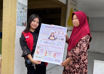 Mahasiswa KKN Unhas menunjukkan Infografis edukasi pencegahan stunting, Rabu (05/02). Foto: Dokumentasi pribadi