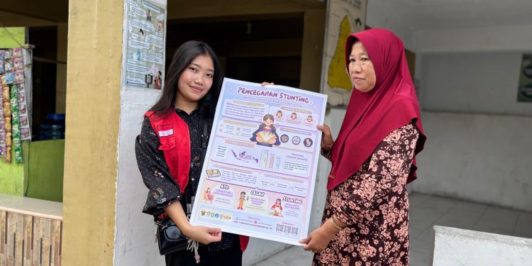 Mahasiswa KKN Unhas menunjukkan Infografis edukasi pencegahan stunting, Rabu (05/02). Foto: Dokumentasi pribadi
