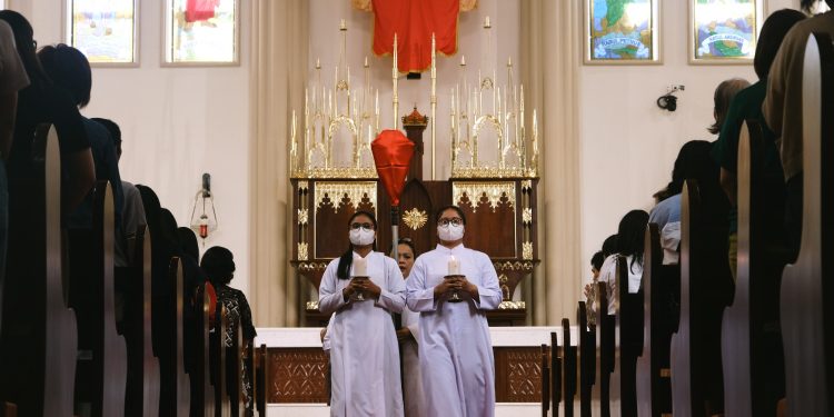 Misdinar berjalan keluar Gereja setelah perarakan salib pada Jalan Salib Jumat Agung