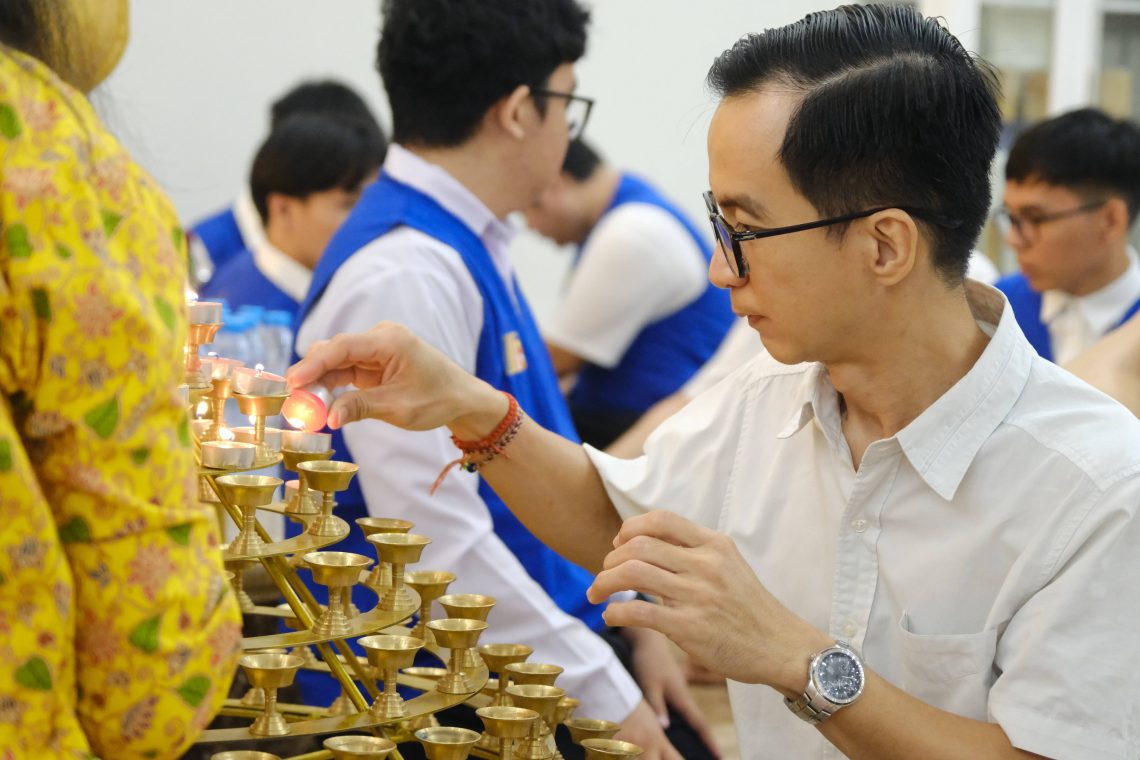 Seorang umat menyalakan lilin di altar