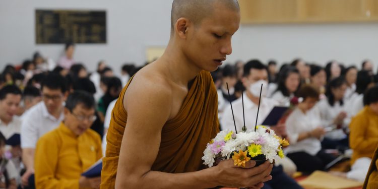 Bhikku memegang rangkaian bunga sebagai simbol persembahan dalam perayaan Waisak