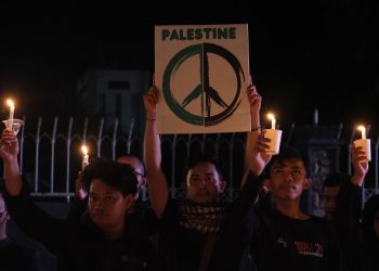 Seorang relawan mengangkat petaka yang merupakan simbol perdamaian untuk Palestina