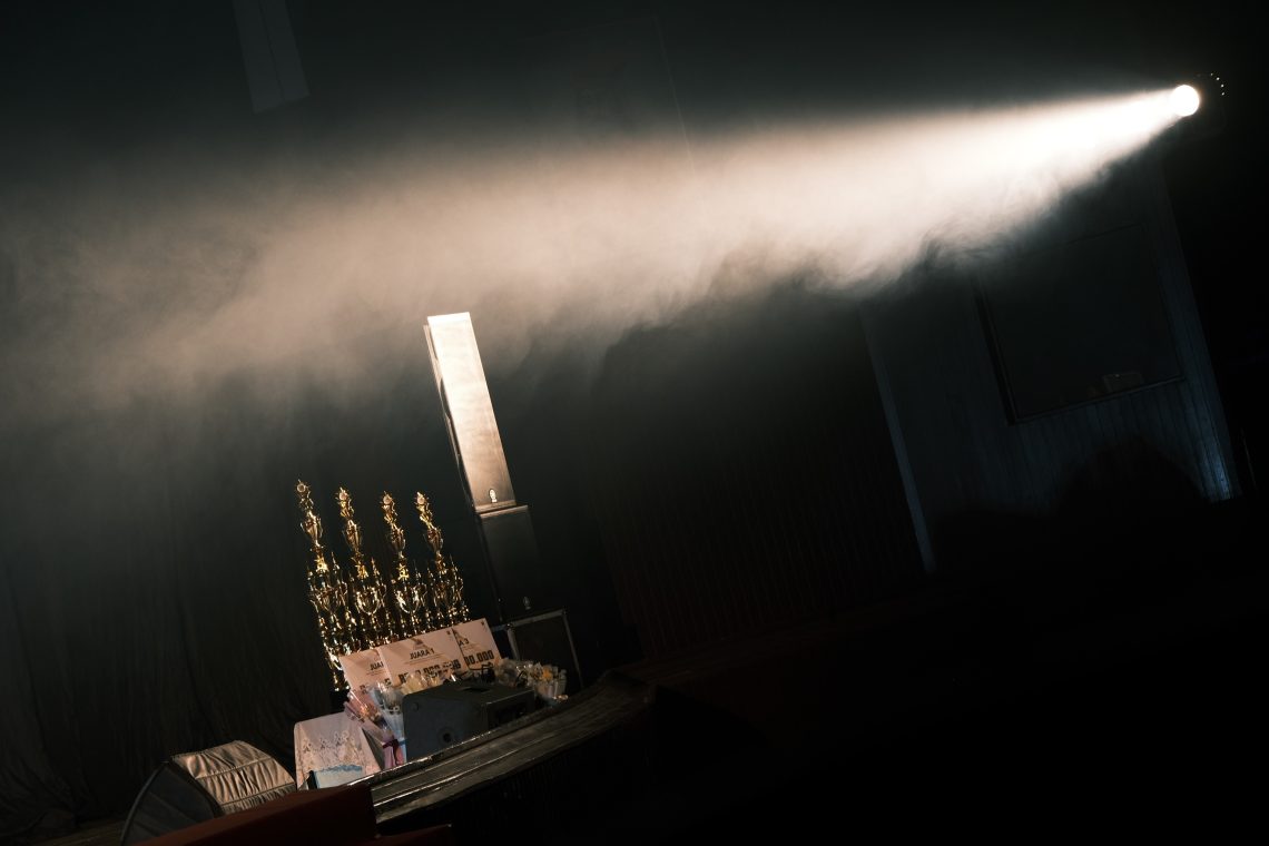 Cahaya lampu yang menyorot piala di sayap kiri panggung Baruga AP Pettarani Unhas