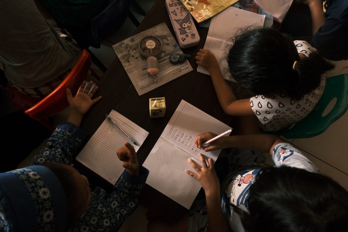 Anak-anak tengah belajar penjumlahan dasar di dalam aula Desa Mata Allo