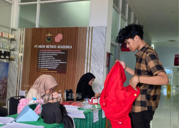 Salah seorang mahasiswa baru saat mengambil jas almamaternya di Gedung Science Techno Park, Minggu (10/08). Foto: IDENTITAS/MAU