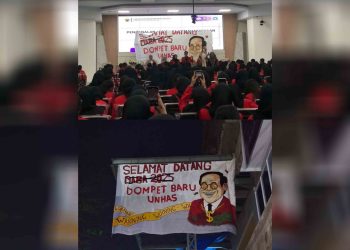 Spanduk bertuliskan "Selamat datang dompet baru Unhas" yang dibentangkan saat PKKMB FKM Unhas 2025 (atas), Rabu (13/08). Spanduk yang sama dipasang di tangga gedung baru FKM Unhas (bawah), Rabu (13/08) dini hari. Foto: Istimewa