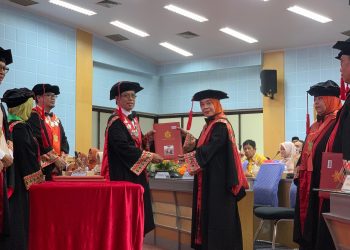 Prof Dr Gustiana A Kambo SIP MSi (kanan) saat menerima buku kode etik anggota Dewan Profesor Unhas pada pengukuhan dan penerimaan anggota Dewan Profesor Unhas di Ruang Rapat Senat Lantai 2, Gedung Rektorat Unhas, Selasa (05/08). Foto: IDENTITAS/Masyita