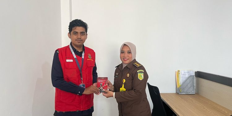 Penyerahan buku saku oleh Muhammad Zulkifli Nur Hariru ke Jaksa Fungsional Kejari Gowa, Rina Mochtar SH MH di Kejari Gowa, Sungguminasa, Jumat (08/08).