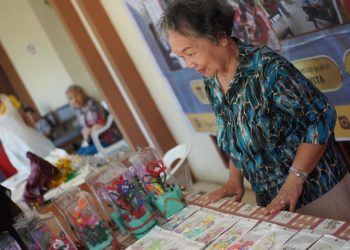 Seorang Lansia yang kerap disapa Oma sedang menjaga tenant pada Pameran Seni Ruang Kreasi Lansia, Minggu (21/9). Foto: Dokumentasi Pribadi