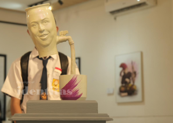 Siswa Sekolah Menengah Pertama (SMP) yang berdiri di balik gerabah berjudul 'Berbagi' karya Ikrar.