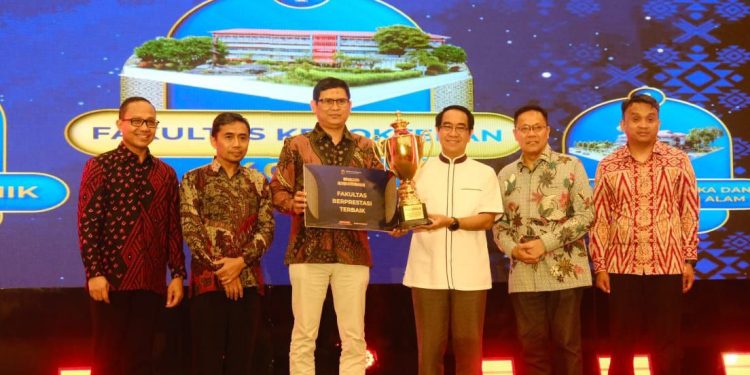 Pimpinan Fakultas Kedokteran bersama Rektor Unhas saat menerima piala bergilir atas penghargaan Fakultas Berprestasi Terbaik dalam Malam Anugerah Kemahasiswaan 2025 di Ballroom Unhas Hotel, Sabtu (27/12). Foto: IDENTITAS/Naufal Ahnaf Khairi.